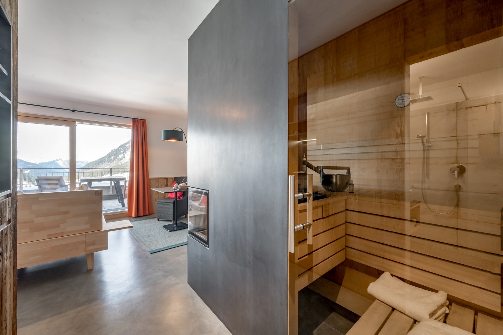 Private SPA Double Deluxe at Chalet Mondschein in Stuben am Arlberg, Austria – in-room private sauna with glass front, rain shower, natural wood interior, fireplace, and terrace with panoramic mountain view